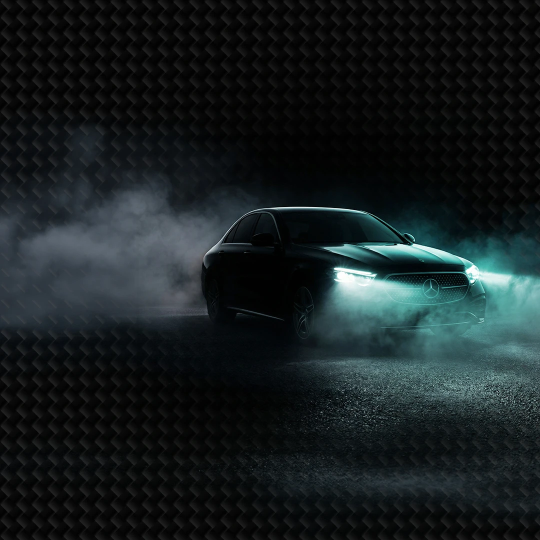 Auto mit eingeschalteten Scheinwerfern im Nebel bei Dunkelheit