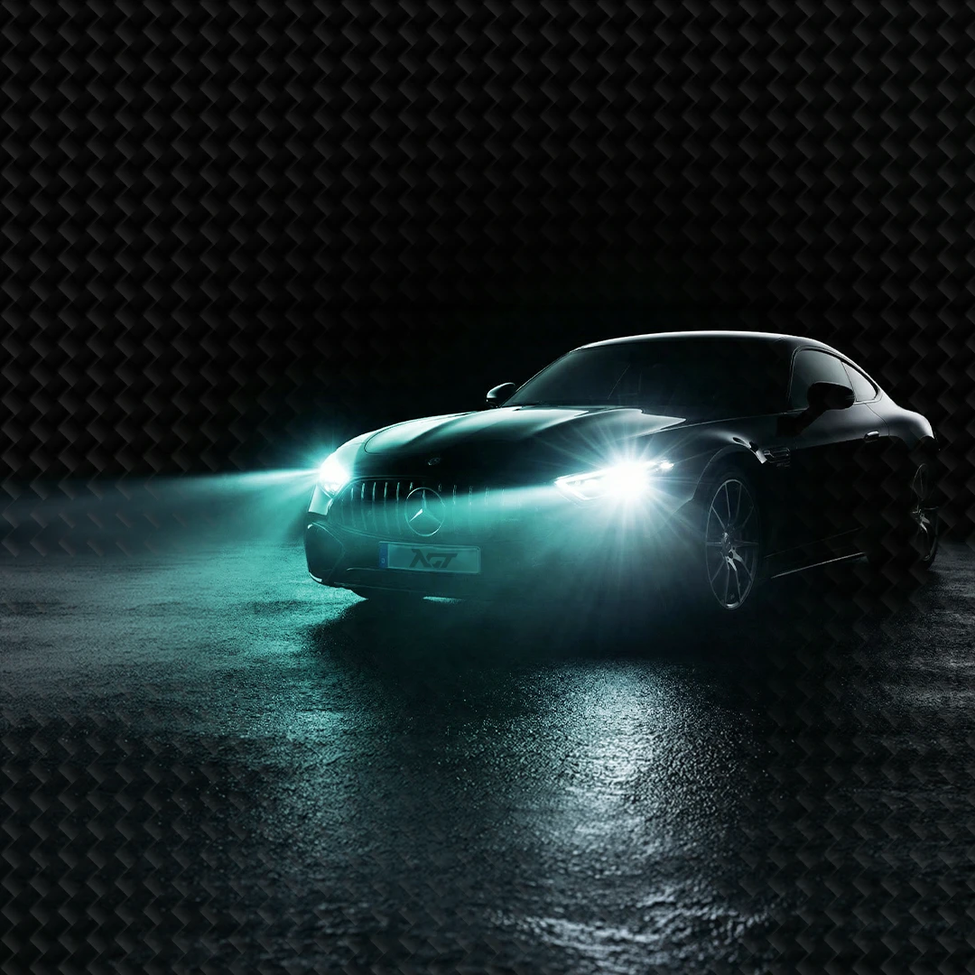 Sportwagen mit eingeschalteten Scheinwerfern auf nasser Straße bei Nacht